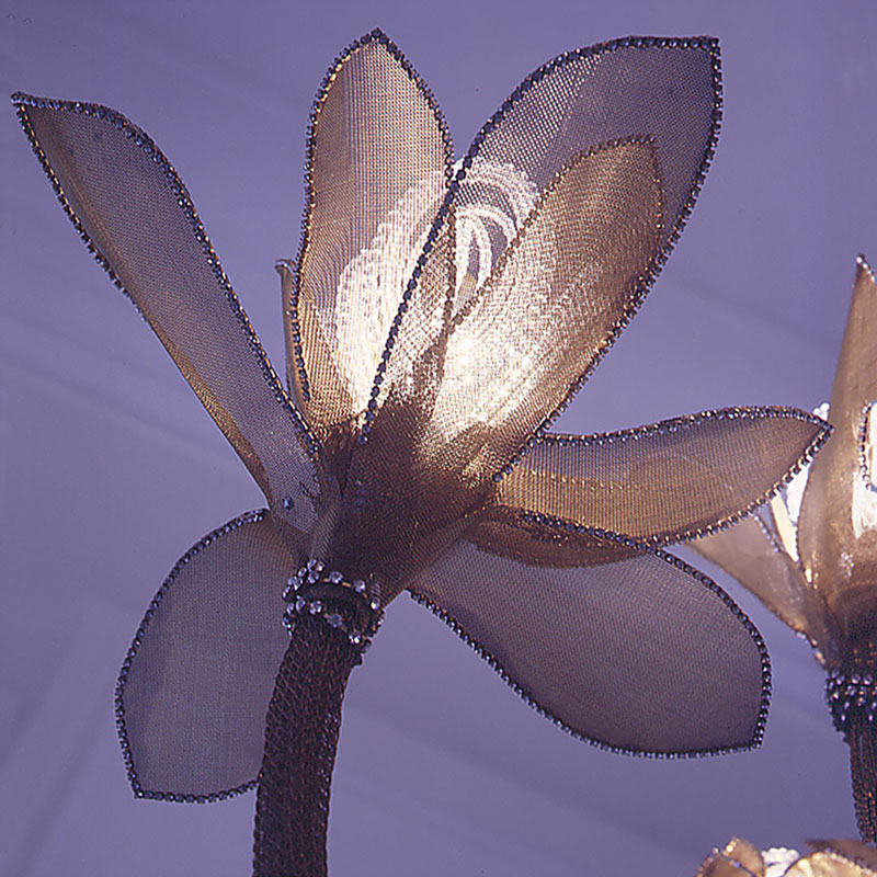 Swarovski Crystal petals at inner layer refract light through woven brass mesh outer petals that are edged with austrian crystals. Each flower sparkles and creates shadows on the ceiling above and around. Swarovski Crystal petals at inner layer refract light through woven brass mesh outer petals that are edged with austrian crystals. Each flower sparkles and creates shadows on the ceiling above and around.